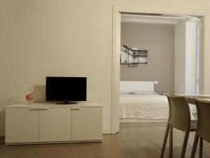 uma sala de estar com televisão num armário com cama em Accademia 35 em Mantova