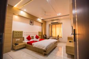a bedroom with a large bed with red pillows at Hotel Fun City in Navsāri +63 photos