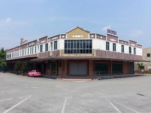 um edifício com um carro rosa estacionado em frente dele em Chemor Inn em Cemur