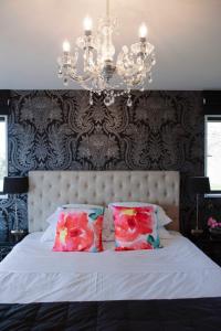 a bedroom with a bed with two pillows and a chandelier at Lake Tekapo Lodge in Lake Tekapo