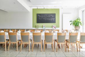 ein Esszimmer mit einem Tisch, Stühlen und einer Tafel in der Unterkunft Schwanenhof Hotel und Restaurant in Erkelenz