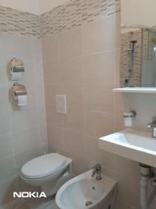 a bathroom with a toilet and a sink at Castellaneta Short Term -Low cost in Castellaneta