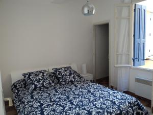 a bedroom with a blue and white bed and a window at Collioure in Collioure