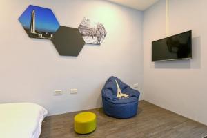 um quarto com uma cama e uma televisão na parede em Lukang Barn Inn em Lukang