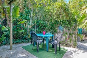 una mesa azul y sillas sobre una alfombra verde con una valla en Cape Agulhas BACKPACKERS, en Struisbaai