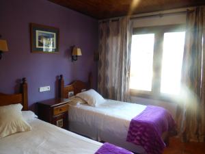a bedroom with two beds and a window at Hotel La Vega in Alcalá de la Selva