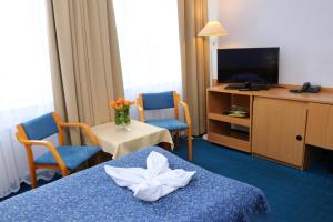 a hotel room with two beds and a tv at Centrum Kołobrzeg in Kołobrzeg