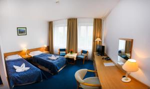 a hotel room with two beds and a desk at Centrum Kołobrzeg in Kołobrzeg +33 photos