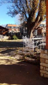 a white bench sitting in front of a tree at Hotel La Vega in Alcalá de la Selva