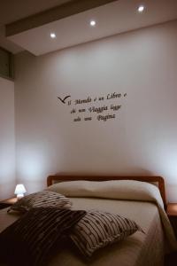 ein Schlafzimmer mit einem Bett mit einem Zitat an der Wand in der Unterkunft I Ragazzi del Borghetto in Marina di Schiavonea