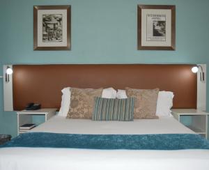 a bedroom with a large bed with white sheets and pillows at The Wilderness Hotel in Wilderness