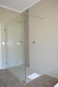 a shower with a glass door in a bathroom at The Wilderness Hotel in Wilderness