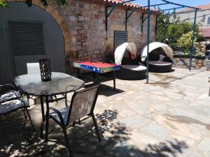 a patio with a ping pong table and chairs at Potamaki Studios & Apartments in Stoupa