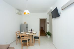 a dining room with a wooden table and chairs at Lovely apartments Balić in Ivan Dolac