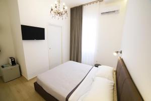a bedroom with a bed and a chandelier at Il Diamante nei Sassi Rooms in Matera +31 photos