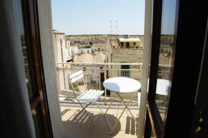 a balcony with two chairs and a view of a city at Il Diamante nei Sassi Rooms in Matera
