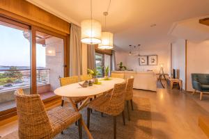 a dining room and living room with a table and chairs at Nuevo Ático Isla de la Toja in Isla de la Toja