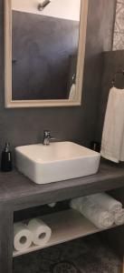 een badkamer met een wastafel, een spiegel en handdoeken bij Panorama Thea in Symi