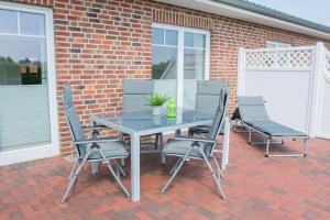 a table and chairs on a brick patio at Am-Kampland-20-Lee in Dahme