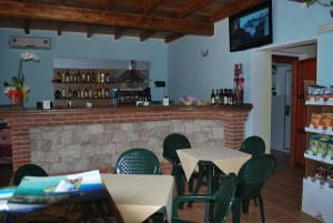 un ristorante con tavoli, sedie e un camino di Punto Di Ristoro Uttolo a Baunei