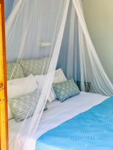 a bed with a mosquito net and pillows on it at Elena Studios & Apartments in Piso Livadi