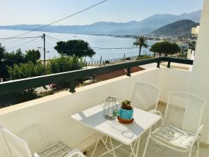 a white table and chairs on a balcony overlooking the water at Liofoto Sea View Apartments in Stalida