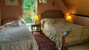 Un dormitorio con dos camas y una ventana. en La Petite Londe, en Biéville-Beuville