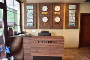 a reception desk with clocks on the wall at Prior Hotel in Prizren