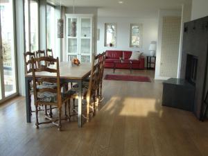 sala de estar con mesa de madera y sillas en B&B 25, en Münchwilen