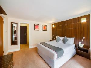 a hotel room with a large bed and a television at OYO The Bridge House Hotel in Reigate