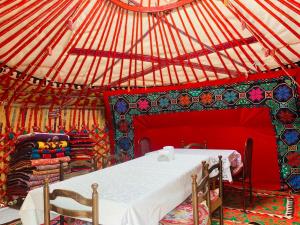 a room with a table and chairs in a yurt at Guest House Aiym in Bokonbayevo