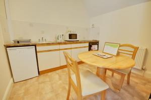 a kitchen with a wooden table with a laptop on it at Somerville Coach House 4 in Bournemouth