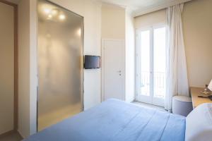 a bedroom with a blue bed and a window at Villa Martini in Castiglioncello