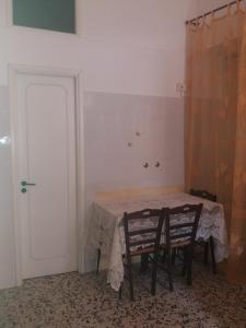 a room with a table and two chairs and a door at Monolocale in via San Sebastiano Ficarra in Ficarra