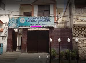 un edificio con un cartel para un hostal en Tourist Lodge Guest House, en Kalar Goth