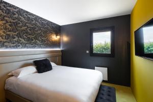 - une chambre avec un lit blanc et une fenêtre dans l'établissement Hotel l'Ortega Rennes Aeroport, à Saint-Jacques-de-la-Lande