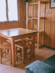 a wooden table and chairs in a room at Bungalows Rurales Picos de Europa in Posada de Valdeón +27 photos