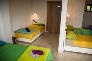 a bedroom with two beds with yellow and green sheets at Adriatrek Bed & Breakfast in Petrovac na Moru
