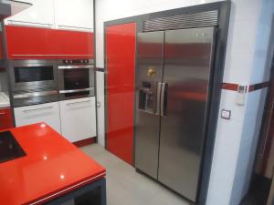 una cocina con nevera de acero inoxidable y armarios rojos en CASA RURAL LA SUITE DE ALMAGRO, en Almagro