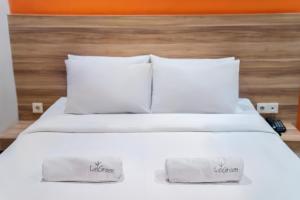 Tempat tidur dalam kamar di LeGreen Suite Supomo