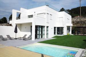 una casa blanca con piscina frente a ella en Casa da Légua, en Moledo