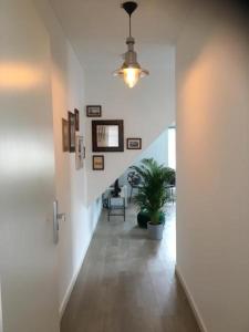 a hallway with a ceiling fan and a potted plant at Kamers van Goud in Katwijk aan Zee