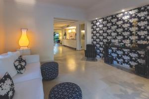 a living room with a white couch and chairs at Villa Martini in Castiglioncello