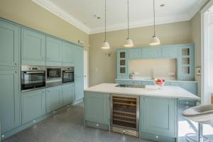 a kitchen with blue cabinets and a white counter top at Carlogie House in Carnoustie