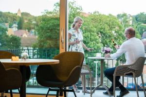 een man en een vrouw aan een tafel op een balkon bij Suites MITTE - Aparthotel in Eisenach