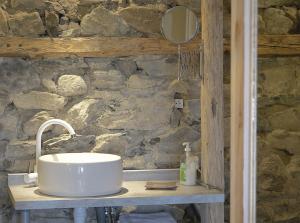 baño con lavabo y pared de piedra en leKarl en Queyrières