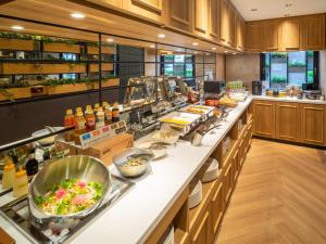 una cocina con una línea de buffet con comida en Super Hotel Tottori Ekimae en Tottori