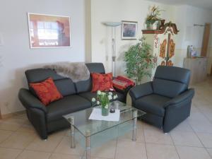 a living room with two couches and a glass table at Ferienwohnung Anderl in Reischenhart