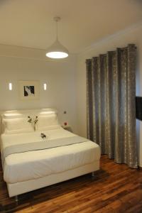 Schlafzimmer mit einem großen weißen Bett und Vorhängen in der Unterkunft Modern and Cozy Apartment in the centre of Athens in Athen