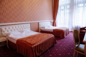 Londonska SPA Hotel في أوديسا: غرفة فندق بها سريران ونافذة